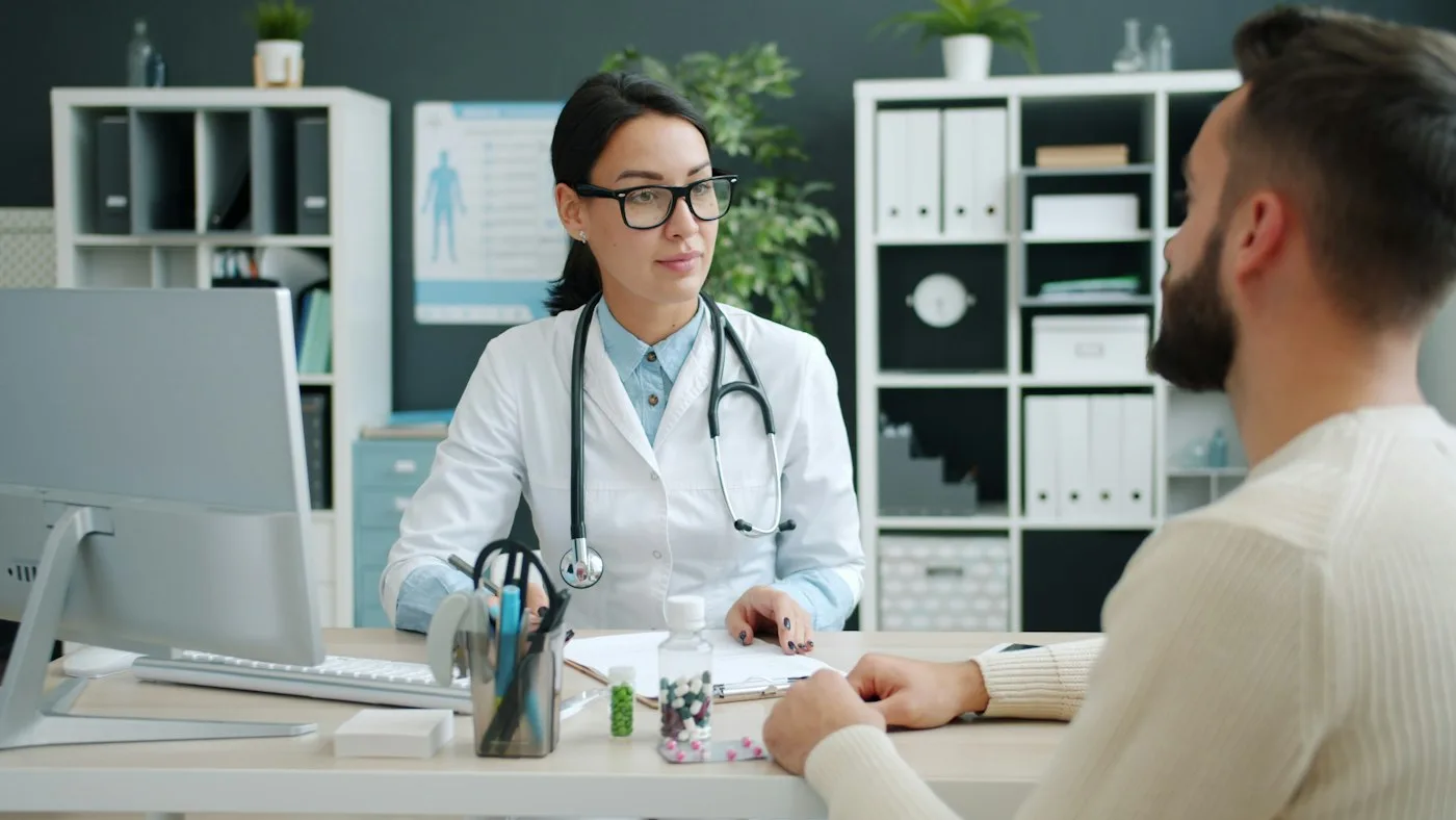 Physician discussing care with a patient at a desk